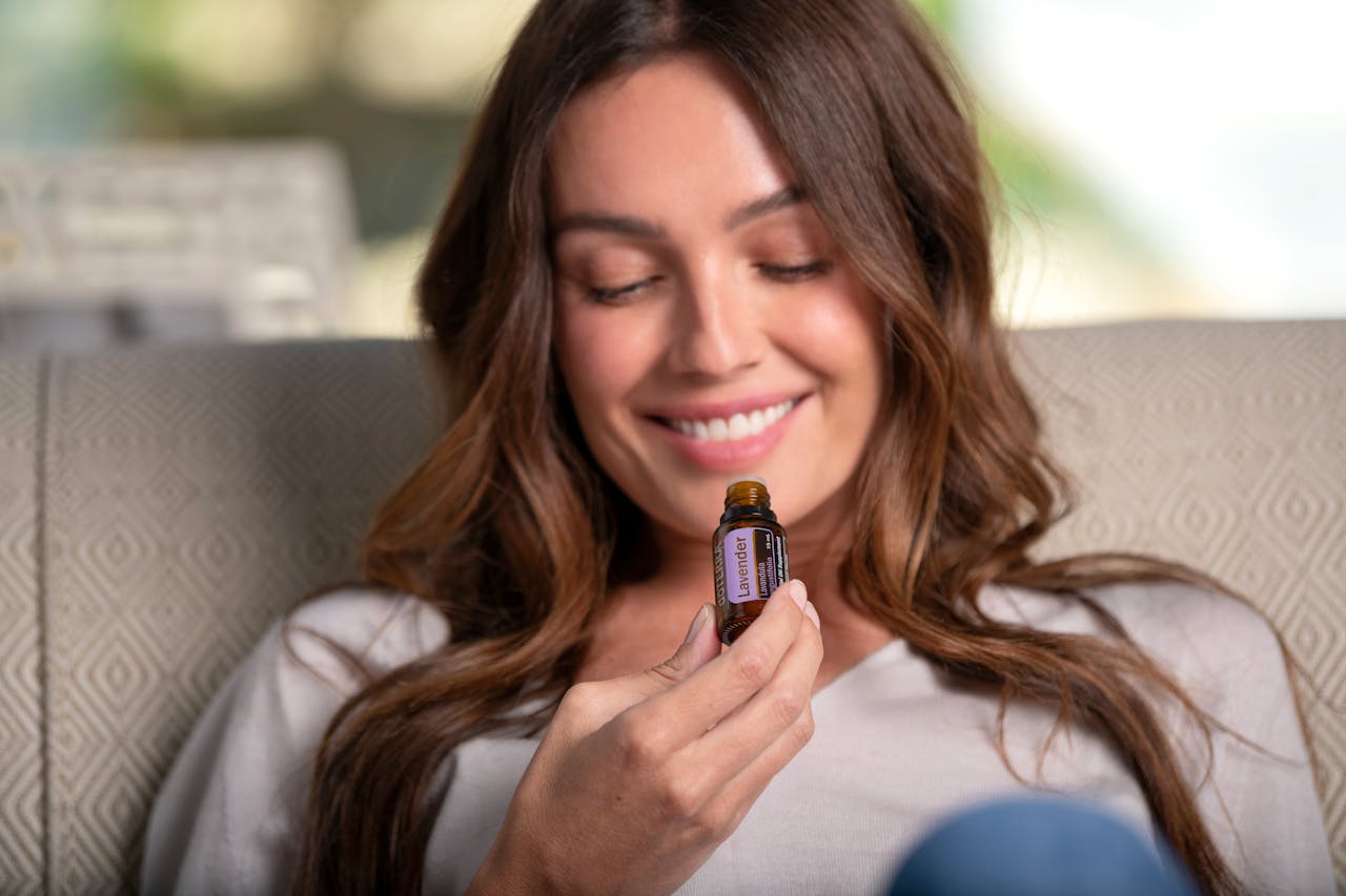 A woman using a roll-on essential oil blend