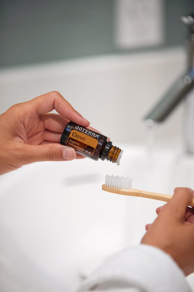 A hand adding drops of essential oil to a diffuser